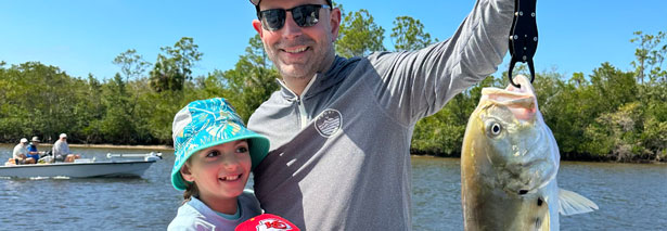 Child catching fish with dad