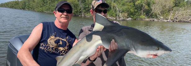Father and son catch shark